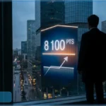 Homme d'affaires regardant un écran de gratte-ciel affichant 8 100 points et une flèche de croissance boursière