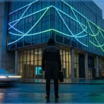Silhouette d'un homme devant un bâtiment moderne aux néons bleus et verts représentant la Fondation Ethereum